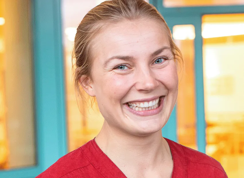 kvinna ler stort och tittar in i kameran
